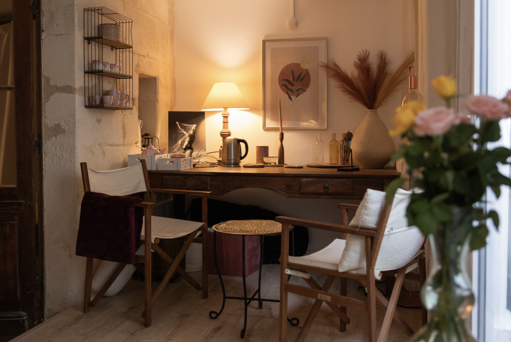 Coin bureau chaleureux avec lampe allumée, chaises en bois et objets décoratifs dans un cabinet bien-être